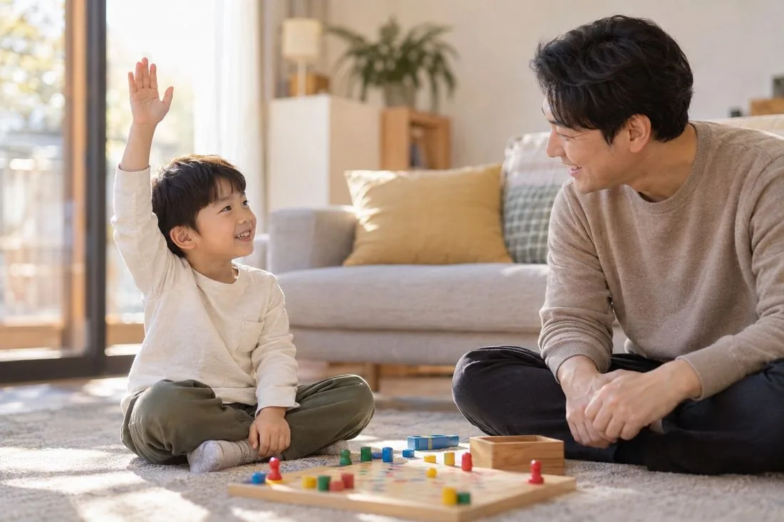 아빠와 아이가 보드게임을 하며 손을 들어 차례를 표현하는 모습
